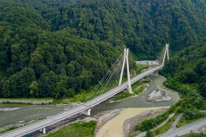 People traveling, road trip on curvy road through beautiful countryside scenery in sunny summer