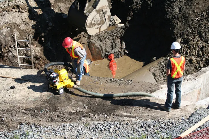 Concrete Construction Workers Pumping Out Water Using Water Inflated Cofferdam