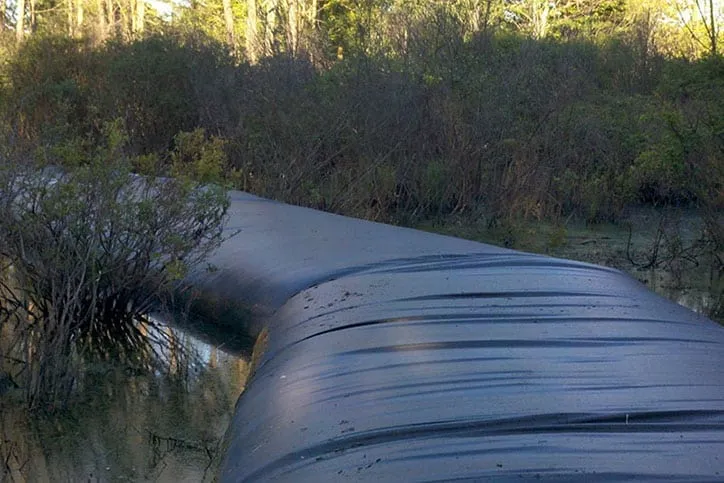 Water filled cofferdam going through river.