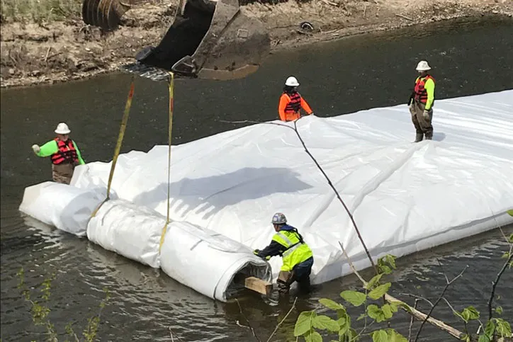 View of Construction Workers Installing a Water Filled Cofferdam