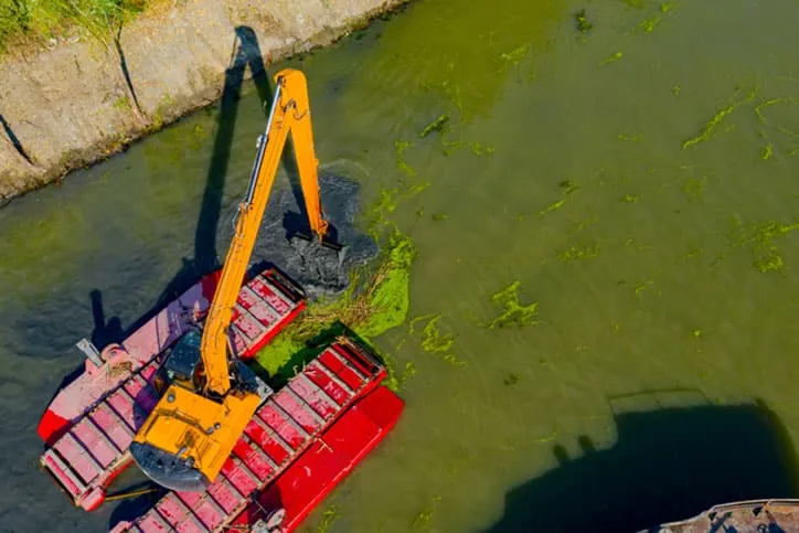 Top down view of dredging on water.