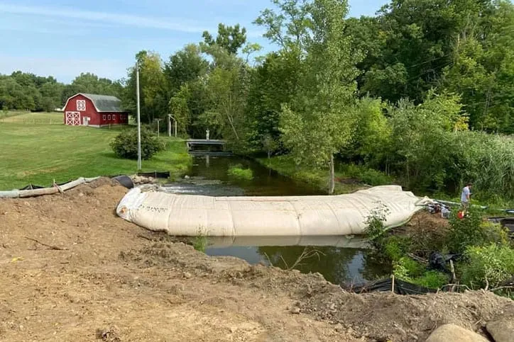 Water inflated barrier near farm and flood zone.