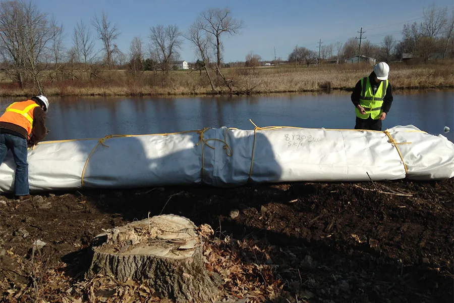 Two Men Unrolling An Inflatable Cofferdam