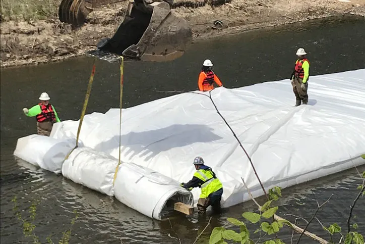 Men Installing a Water-Filled Cofferdam With Dam-It-Dams