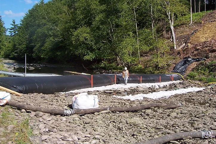 Construction Worker Setting Up An Inflatable Cofferdam