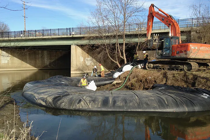 Workers Near Bridge and Water Using Water Inflated Cofferdam for Construction