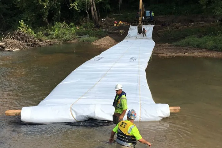 Men Installing Inflatable Cofferdam On River