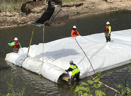 Crew installing a cofferdam in Texas river.