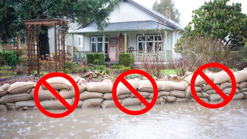 Sandbags in front of home while flooding in street.